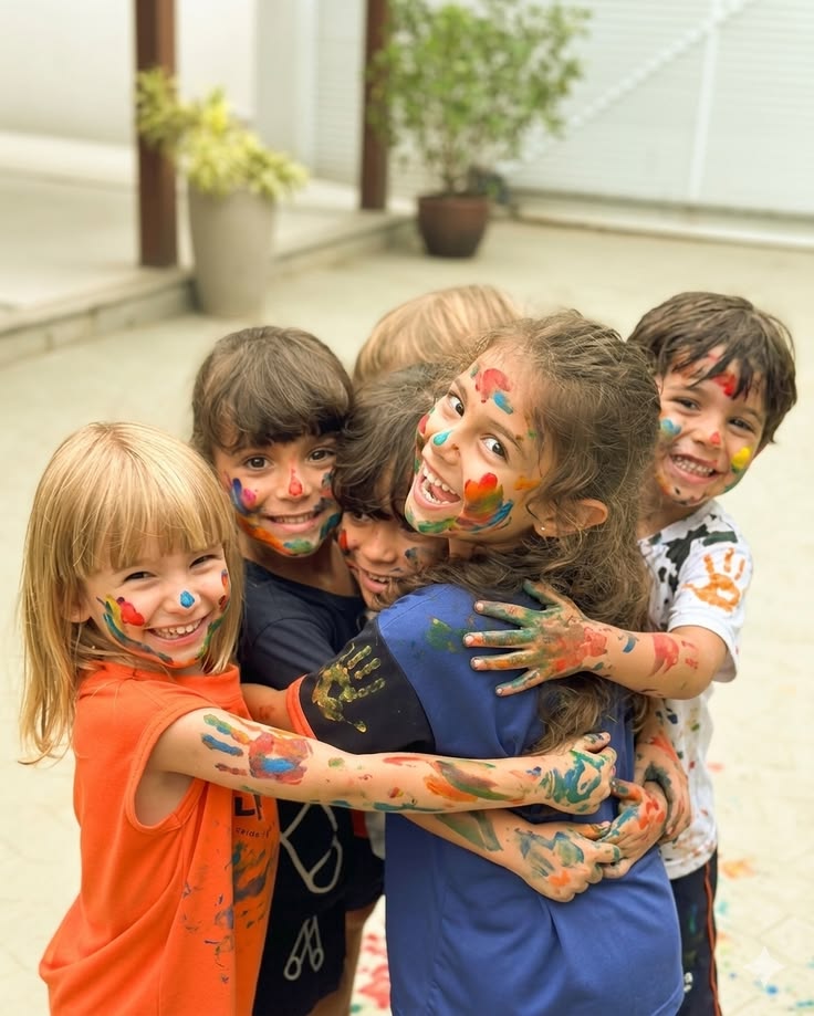 Crianças sorrindo durante uma atividade com tintas